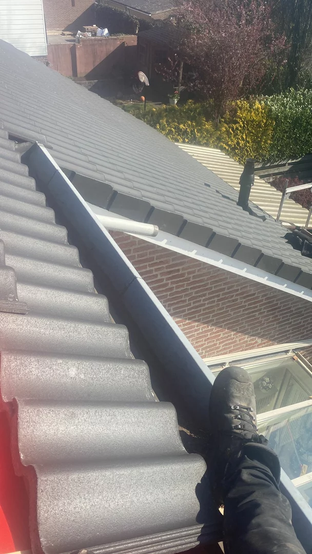 Vakman aan het werk op een hellend dak